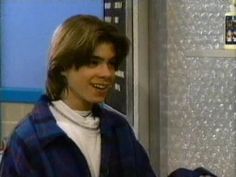 a young man standing in front of a refrigerator