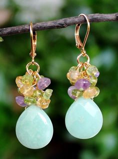 A gorgeous Chrysoprase natural stone, an one-of-a-kind natural gemstone hand-picked for its color and beauty. This lovely pair of earrings features a beautiful Chrysoprase natural stone, with small clusters of amethyst, peridot and citrine gemstones. dangles on a gold ear wire. Each stone may vary slightly in size and shape. Earrings measures 1.75 inches in length. This stunning cluster earrings is unique, feminine and eye-catching, Perfect for anyone that wants to make a statement or to wear to Chrysoprase Gemstone Drop Earrings, Chrysoprase Gemstone Dangle Jewelry, Green Multi-stone Dangle Jewelry, Peridot Dangle Earrings, Peacock Pearl, Yellow Citrine, Citrine Gemstone, Green Peridot, Cluster Earrings