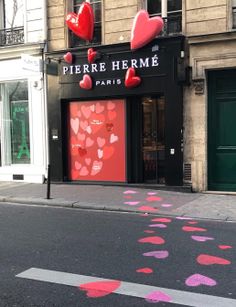 there are hearts painted on the street in front of storefronts that say pierre herme paris