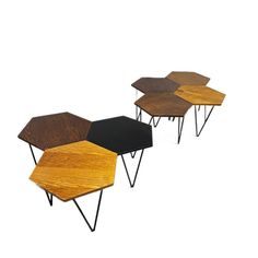 three wooden tables with metal legs and black tops, one on top of the other