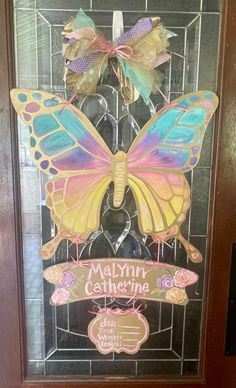 a butterfly shaped door hanger with the name melyn's gathering on it