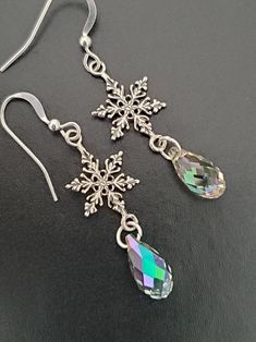 "Celebrate the holidays with these beautiful sterling silver snowflake and Swarovski crystal winter earrings. They also make a great gift for Christmas or Hanukkah! These gorgeous earrings are made with solid.925 sterling silver snowflake charms and ear wires. Choose from French or lever back ear wires. The Swarovski crystals are a gorgeous Luminous Green color. The drop is a Faceted Briolette cut and is 11 mm in length. The crystal almost clear with a hint of sage and olive green. The length of Sparkling Snowflake Jewelry In Sterling Silver, Snowflake Shaped Sparkling Sterling Silver Jewelry, Sparkling Snowflake Sterling Silver Jewelry, Silver Snowflake Jewelry For Holidays, Sparkling Snowflake Jewelry For Gifts, Holiday Silver Snowflake Jewelry, Silver Sparkling Crystal Earrings For Gift, Sparkling Silver Christmas Jewelry, Sparkling Dangle Crystal Earrings Gift