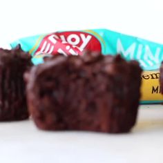 three pieces of chocolate cake sitting on top of a white table next to a candy bar