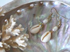 Unique ocean inspired earrings made with gold plated earring hooks, Pearls and cowrie shells. Gold Teardrop Earrings For The Beach, Gold Teardrop Jewelry For Beach, Gold Teardrop Jewelry For The Beach, Gold Pearl Earrings As Summer Gift, Gold Pearl Earrings Perfect For Summer Gifts, Gold Pearl Earrings For Summer Gifts, Nickel-free Gold Earrings For Vacation, Gold Nickel-free Earrings For Vacation, Gold Drop Earrings For Vacation