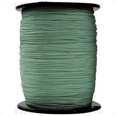 a spool of green thread on a white background