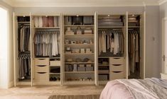 an organized bedroom closet with clothes and other items on the shelves in front of it