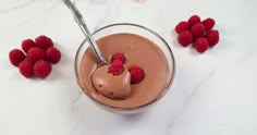 there is a chocolate dessert with raspberries on the side and a spoon in it