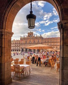 people are sitting at tables under an archway