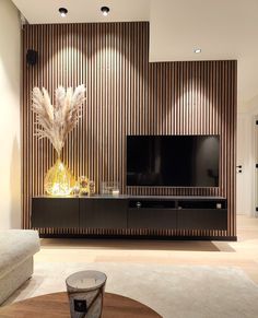 a living room with a large television on top of a wooden entertainment center in front of a wall mounted flat screen tv