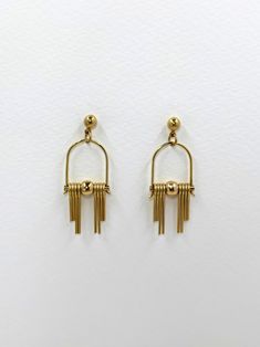 These Art Deco inspired earrings feature sleek, modern design elements, highlighting the radiant golden brass. Each earring boasts a distinctive arched geometric shape inspired by the Art Deco style, lending a sense of elegance and sophistication.  The stepped cut brass fringe creates movement and shine and adds to the uniqueness and contemporary design.  Their minimalist yet bold design embodies a harmonious balance between simplicity and intricacy, making them a versatile accessory suitable for both formal occasions and everyday wear. Each earring is finished with a brass ball stud with stainless steel post. Approximate measurements- 4.5 long 1.5cms wide These earrings are available in three variations- -Black Agate semi precious stone -Green Agate semi precious stone  -All Brass Please Minimalist Metal Dangle Chandelier Earrings, Modern Gold Plug Earrings, Modern Dangle Plug Earrings, Modern Gold Dangle Chandelier Earrings, Modern Dangle Chandelier Earrings, Modern Gold Brass Chandelier Earrings, Modern Gold Metal Chandelier Earrings, Modern Gold Dangle Threader Earrings, Modern Yellow Gold Dangle Chandelier Earrings