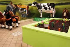 toy farm animals and toys are on display in the children's play area at the museum