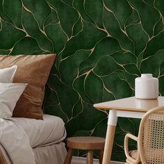 a bedroom with green wallpaper and white bedding, two chairs and a table