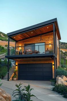 a house with a garage in front of it on the side of a hill at dusk