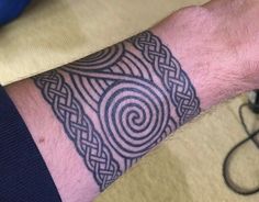 a man's arm with a tattoo on it and a spiral design in the middle