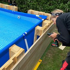 a woman is using a drill to build a swimming pool