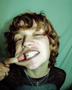 a young man making a silly face while brushing his teeth