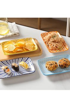 there are four different plates on the table with food and drinks in them, one is empty