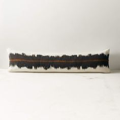 a black and white pillow sitting on top of a table