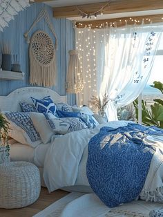 a bedroom decorated in blue and white with lights on the windowsill, bed linens are laid out