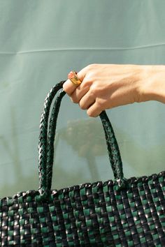 Forest green and black check woven leather tote with tonal woven handles. Tote measures W: 11.75 x D: 5.5" x 9.75" with a 7" Handle Drop. Fabric is 100% Buffalo Leather. *Buffalo leather develops a beautiful patina by deepening in color over time. It is vulnerable to water stains and tonal changes from the sun. It is recommended to avoid contact with lighter fabrics, as vegetable dyes have the potential to transfer. Green Woven Leather Shoulder Bag For Everyday Use, Green Woven Leather Shoulder Bag For Errands, Green Bags With Braided Handles For Everyday, Everyday Green Woven Leather Shoulder Bag, Green Shoulder Bag With Round Handle For Everyday, Everyday Green Shoulder Bag With Round Handle, Green Bag With Intrecciato Weave For Everyday Use, Green Woven Leather Shoulder Bag With Double Handle, Green Woven Leather Shoulder Bag For Shopping