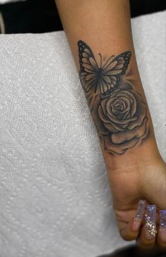 a woman's foot with a butterfly on it and a rose in the middle