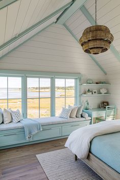 a bedroom with two windows and a bed in the corner, along with a rug on the floor