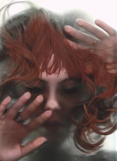 a woman with red hair covering her face