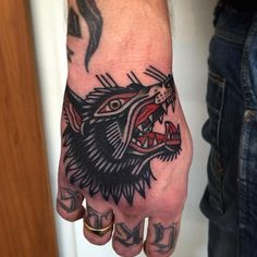 a man's hand with a tattoo on it and a wolf head in the middle