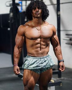 a shirtless man with no shirt standing in front of a gym machine