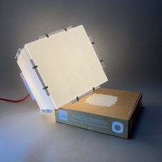 an open box sitting on top of a table next to a red cord and light