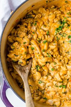 a pot filled with macaroni and cheese on top of a white tablecloth