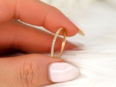 a woman's hand holding a gold ring with diamonds on the inside of it