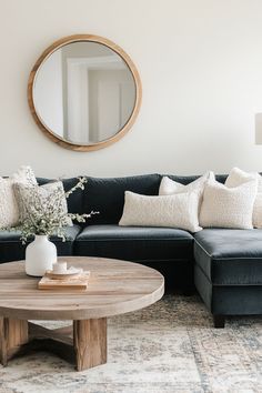 a living room with a couch, coffee table and round mirror on the wall above it