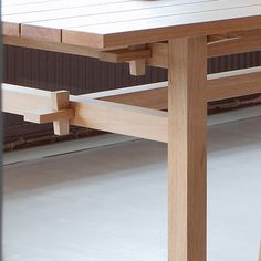 a close up of a wooden table with a bowl of fruit on top of it