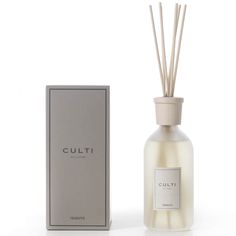 a white bottle next to a box with a reed diffuser on top of it