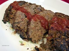 meatloaf with ketchup on a white plate