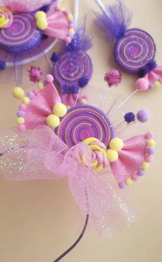 there is a pink and purple flower decoration on the table next to some candy lollipops