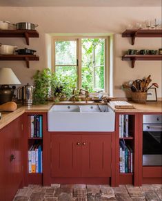 a kitchen with red cabinets and white sink