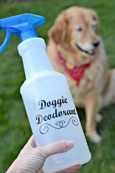 a person holding a dogue deodorant spray bottle in front of their dog