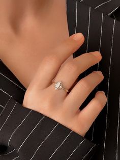 a woman's hand wearing a ring with a diamond in the middle and on top of her finger