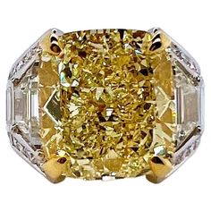 This stunning sunshine yellow diamond will be the talk of the town! The center diamond is a fancy yellow GIA-certified cushion cut with a custom-made setting with 1 ct trapezoid diamonds on each side. The round diamonds and baguettes finish out the custom mounting. The more modern approach of this design will grasp everyone's attention and will complete anyone's jewelry collection! Yellow Diamond: 11.49 cts / VS1 Fancy Yellow / GIA-certified Diamonds: 2.00 cts Trapezoid Cut total weight Diamonds Leather Wedding Shoes, Diamond Bracelet Design, Fancy Yellow Diamond, Talk Of The Town, White Diamond Ring, Diamonds Ring, Sunshine Yellow, Expensive Jewelry, The Talk