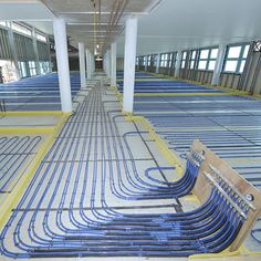 pipes are lined up in the middle of an empty room with yellow and blue piping