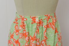 "Info: ♥ Circa: late 60s ♥ Label: Lilly Pulitzer ♥ Color: Orange, green, white ♥ Material: Polyester and cotton blend ♥ Condition: Very good vintage condition. A couple spots on waistband. Details: ♥ 60s era maxi skirt by Lilly Pulitzer ♥ Amazing, bright butterfly novelty print ♥ Large ruffle and scalloped eyelet trim at hem ♥ Unlined ♥ Back metal zipper and button closure Measurements: Waist: 26.5\" Hips: 45\" Length: 44\" ♥ ♥ All garments are measured flat, then doubled for the bust, waist, an Retro Cotton Skirt With Elastic Waistband, Retro Summer Skirt For Daywear, Retro Cotton Skirt For The Beach, Retro Cotton Beach Skirt, Summer Vintage Skirt With Retro Print, Orange Floral Maxi Skirt, Vibrant Print Summer Skirt, Orange Floral Print Long Skirt, Vintage Cotton Beach Skirt