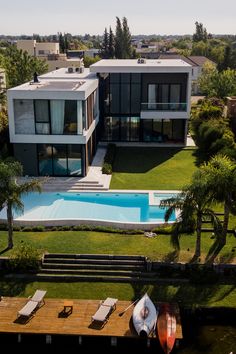 an aerial view of a house with a swimming pool and lounge chairs in the foreground