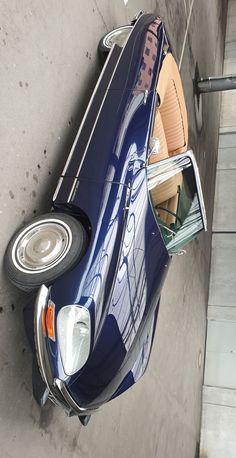 a blue sports car parked next to a building