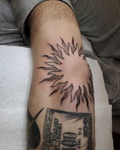 a man's arm with a tattoo on it and a dollar bill in the center