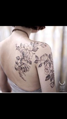 the back of a woman's shoulder with flowers on it