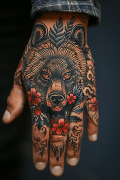 a person's hand with tattoos on it and a bear tattoo on the palm