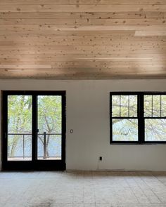 an empty room with two large windows and no one in the room or there is anything else