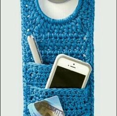 a cell phone is in a blue crocheted case with a pocket for it